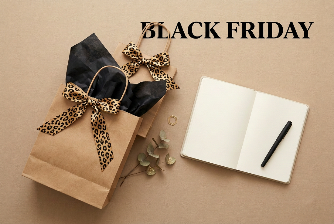 BLACK FRIDAY wording above kraft shopping bags with leopard-print ribbons and an open notebook.