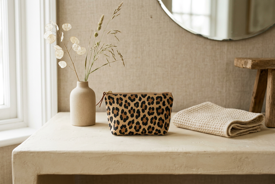 Leopard-print pouch styled on a neutral dressing table as a small decorative accent.