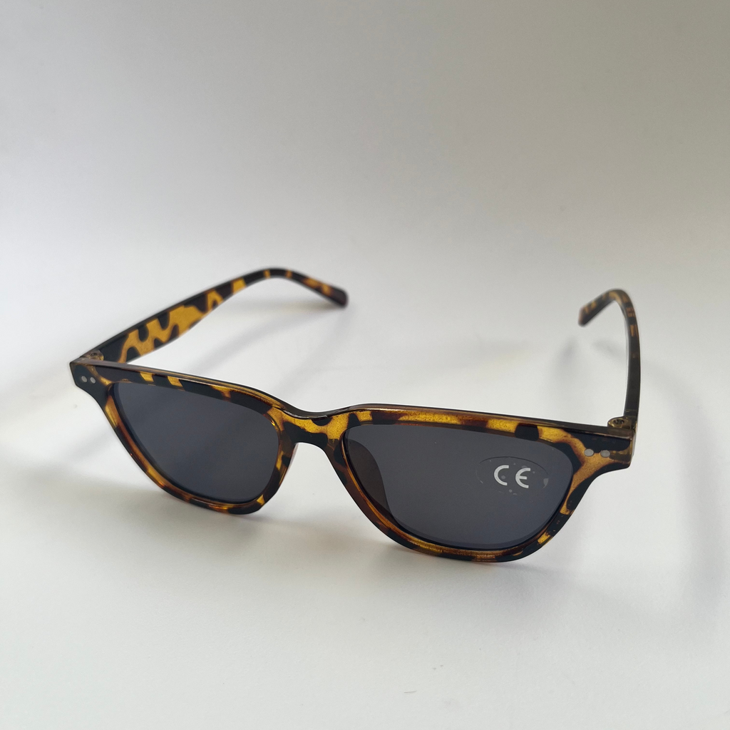 Sunglasses frame and dark lenses on a light gray background