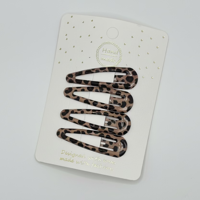 Set of leopard print hair clips on a white card with gold text on a gray background