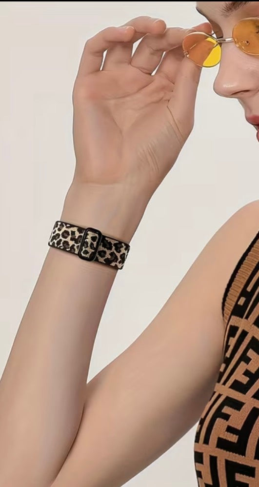 Person wearing a leopard print wristband with a neutral background