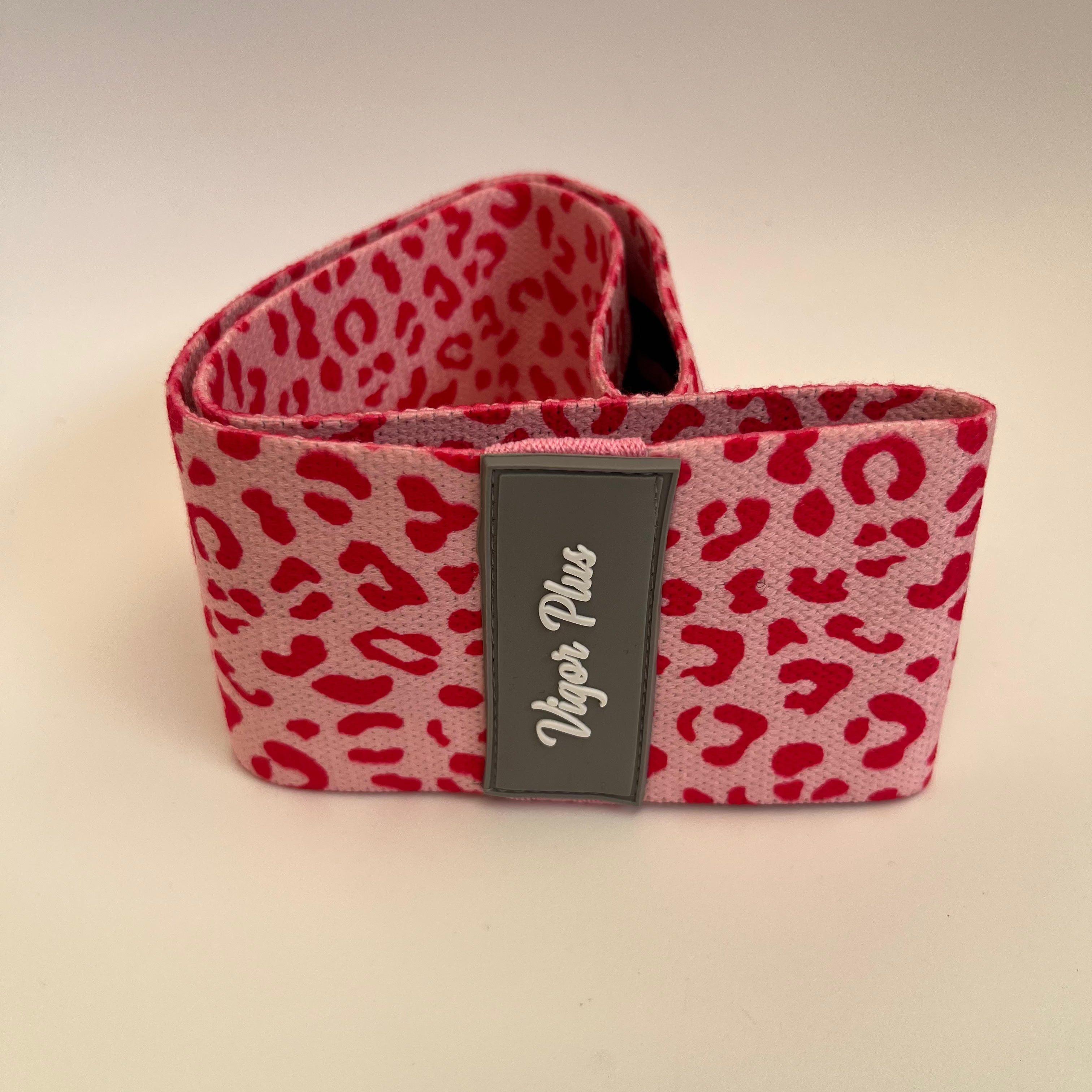 Red leopard print product with a visible brand label on a beige background