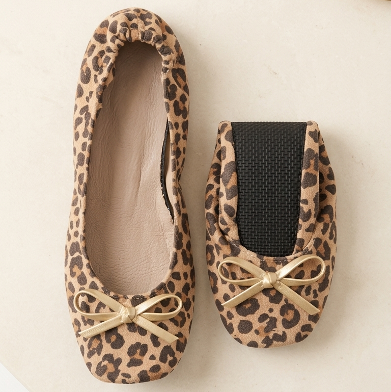 Leopard print ballet flats with gold accents on a light background