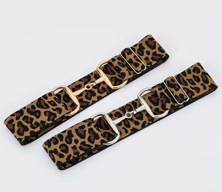 Two leopard print belts with gold buckles on a light gray background