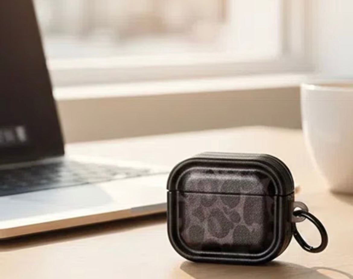 Black leopard print case on a desk with a laptop and mug in the background