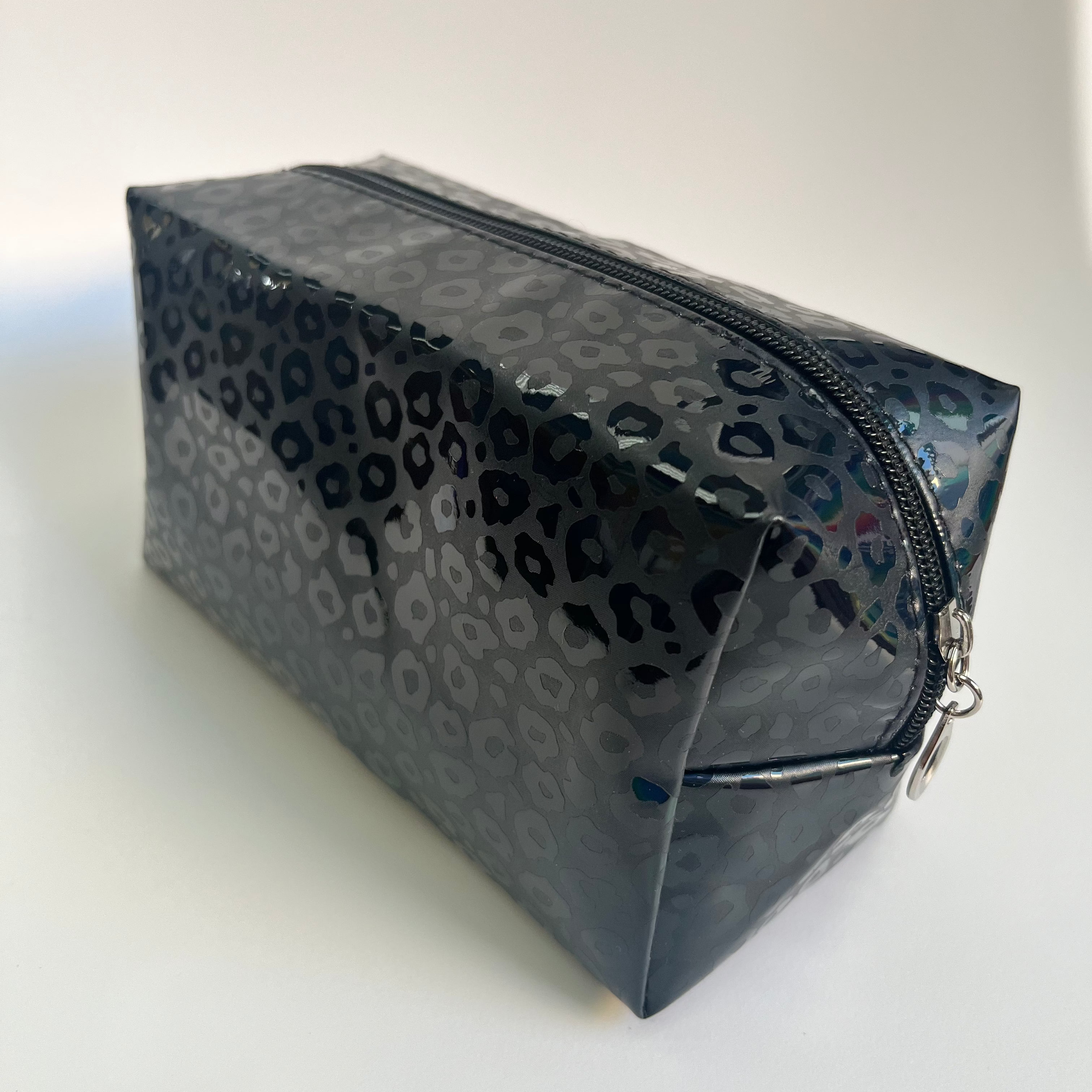 Clear cosmetic bag with black leopard print pattern on a white background