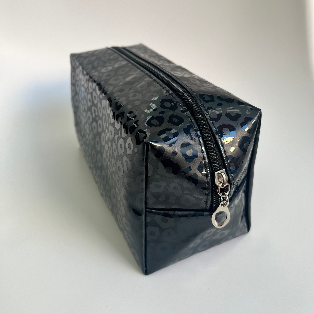 Black leopard print makeup bag with a silver zipper on a white background