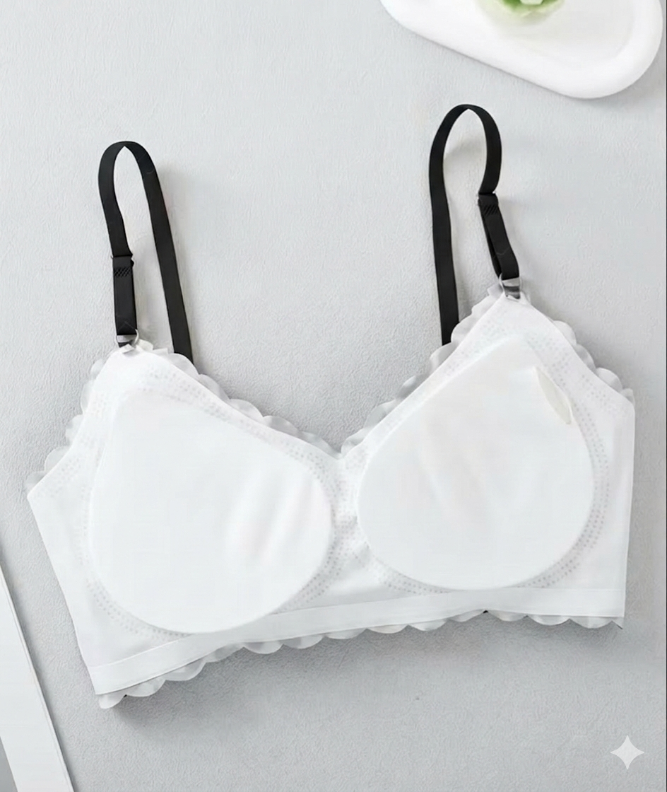 White back of bra with black straps on a light gray background