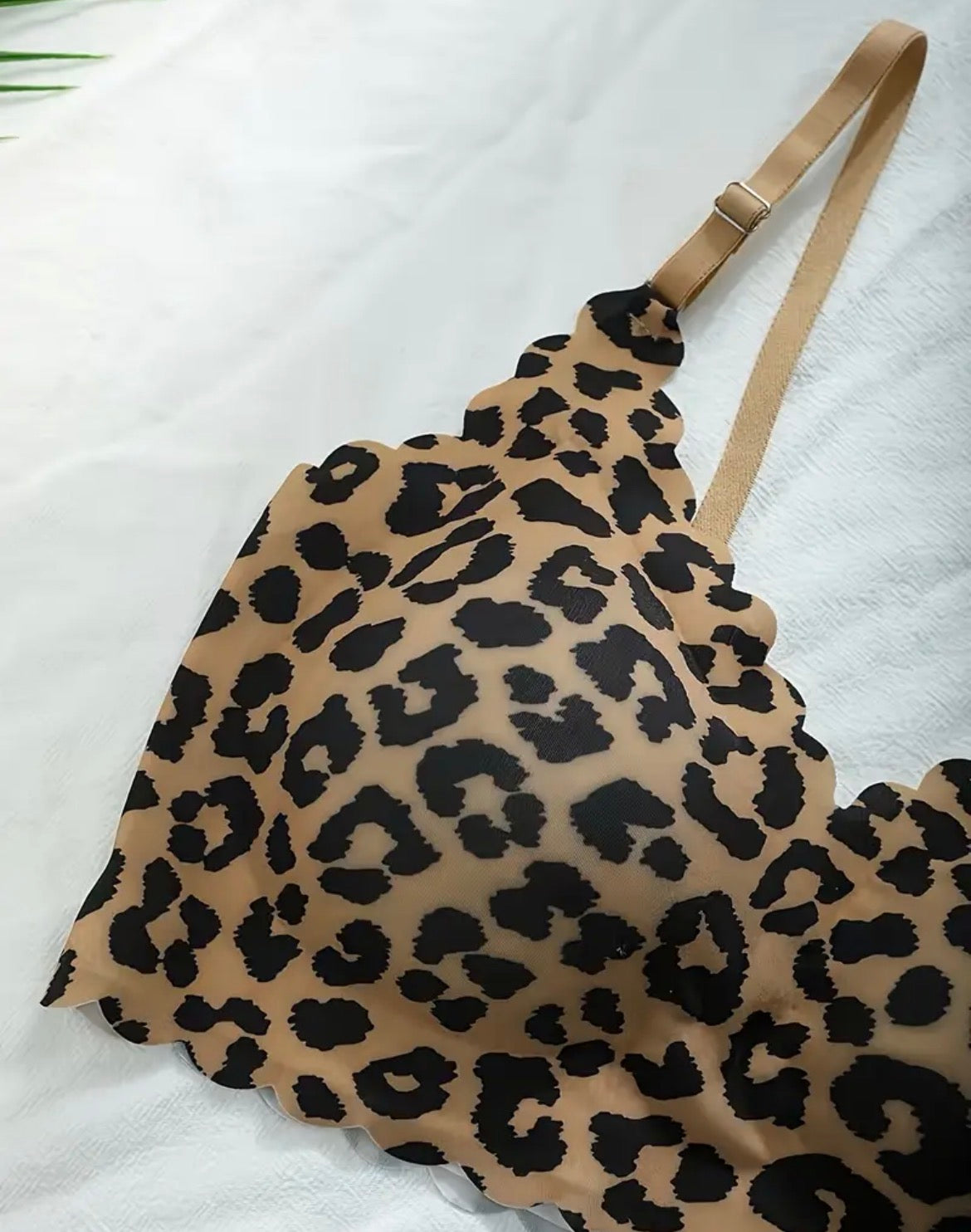 Leopard print bra with a beige strap on a white background