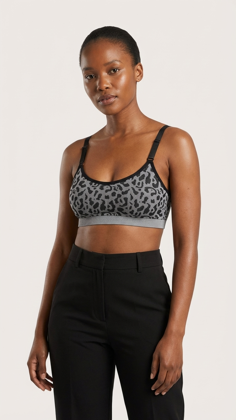 Woman wearing a leopard print sports bra and black pants on a white background