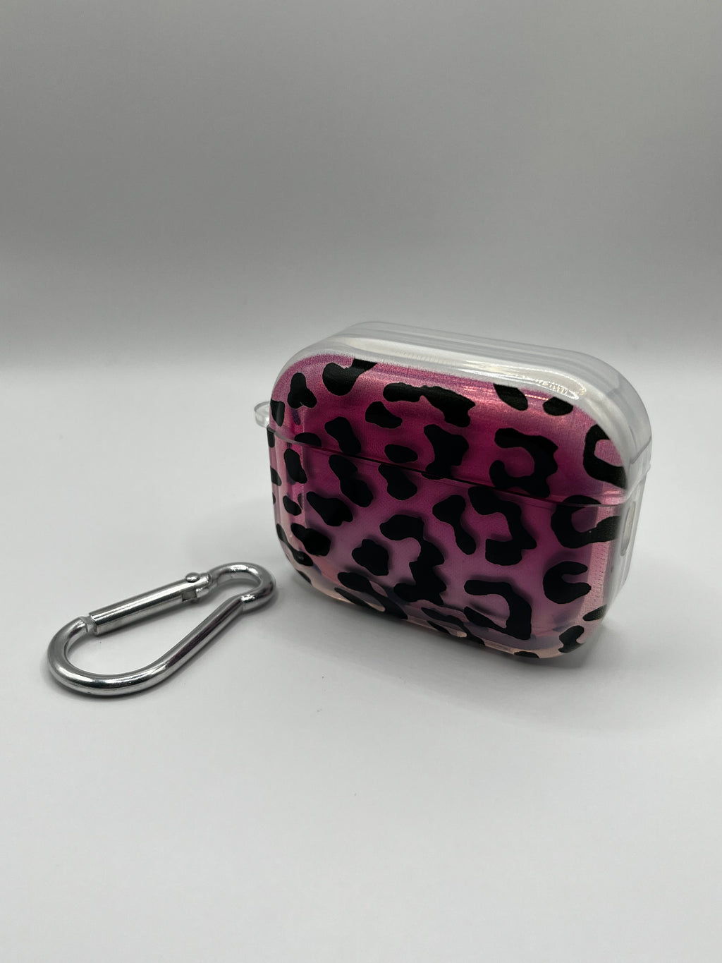 Pink leopard print case with a carabiner on a gray background