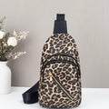 Leopard print sling bag on a white surface with a gray background