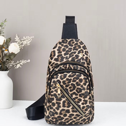 Leopard print sling bag on a white surface with a gray background