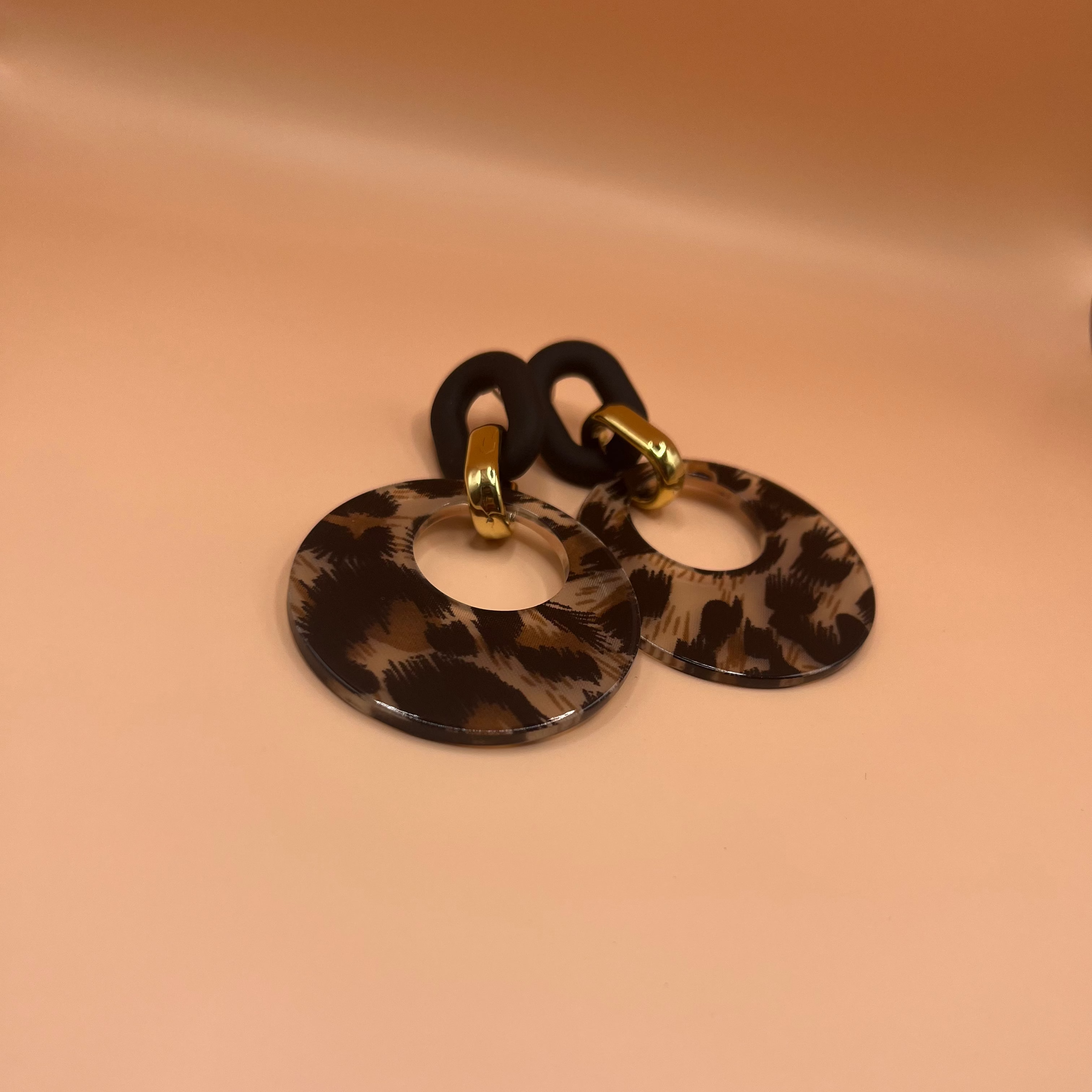 Pair of earrings with leopard 
design on a beige background