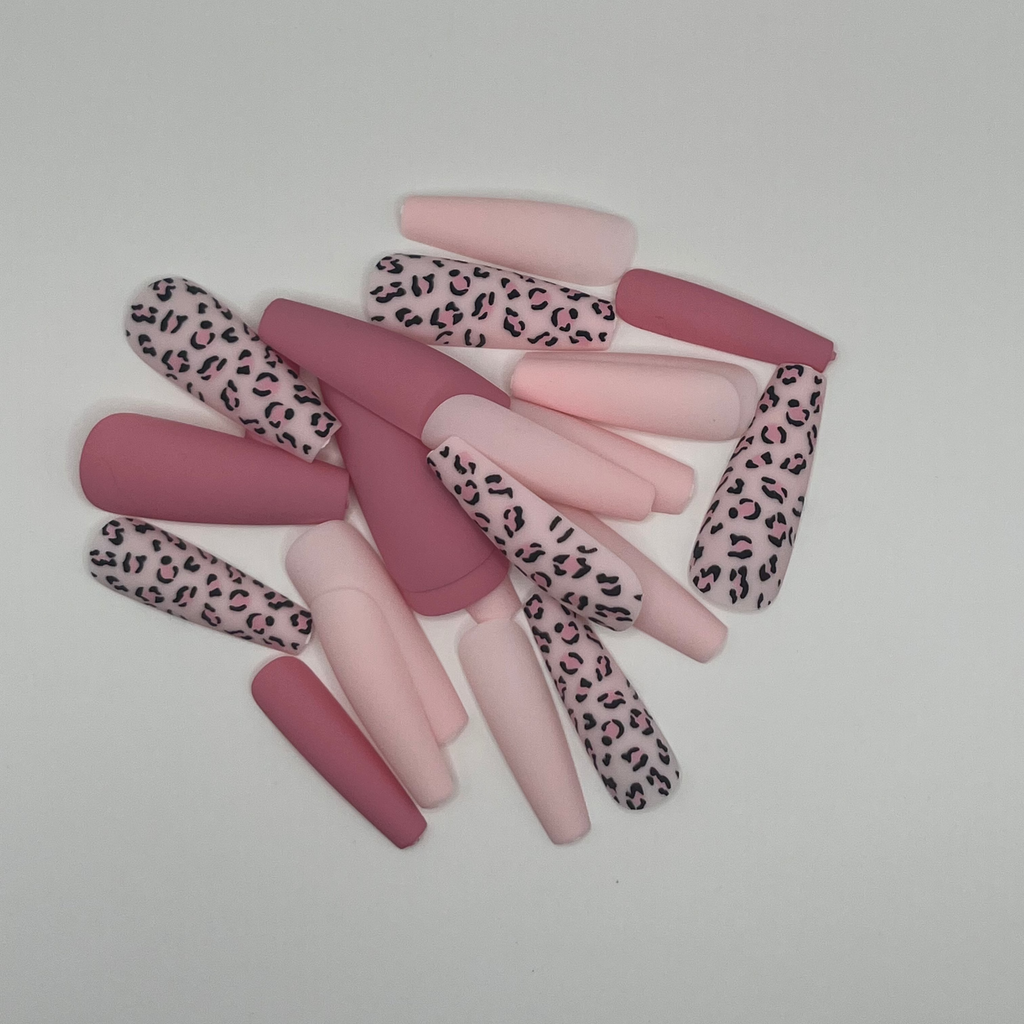 Set of false nails with leopard print and solid colors on a light gray background