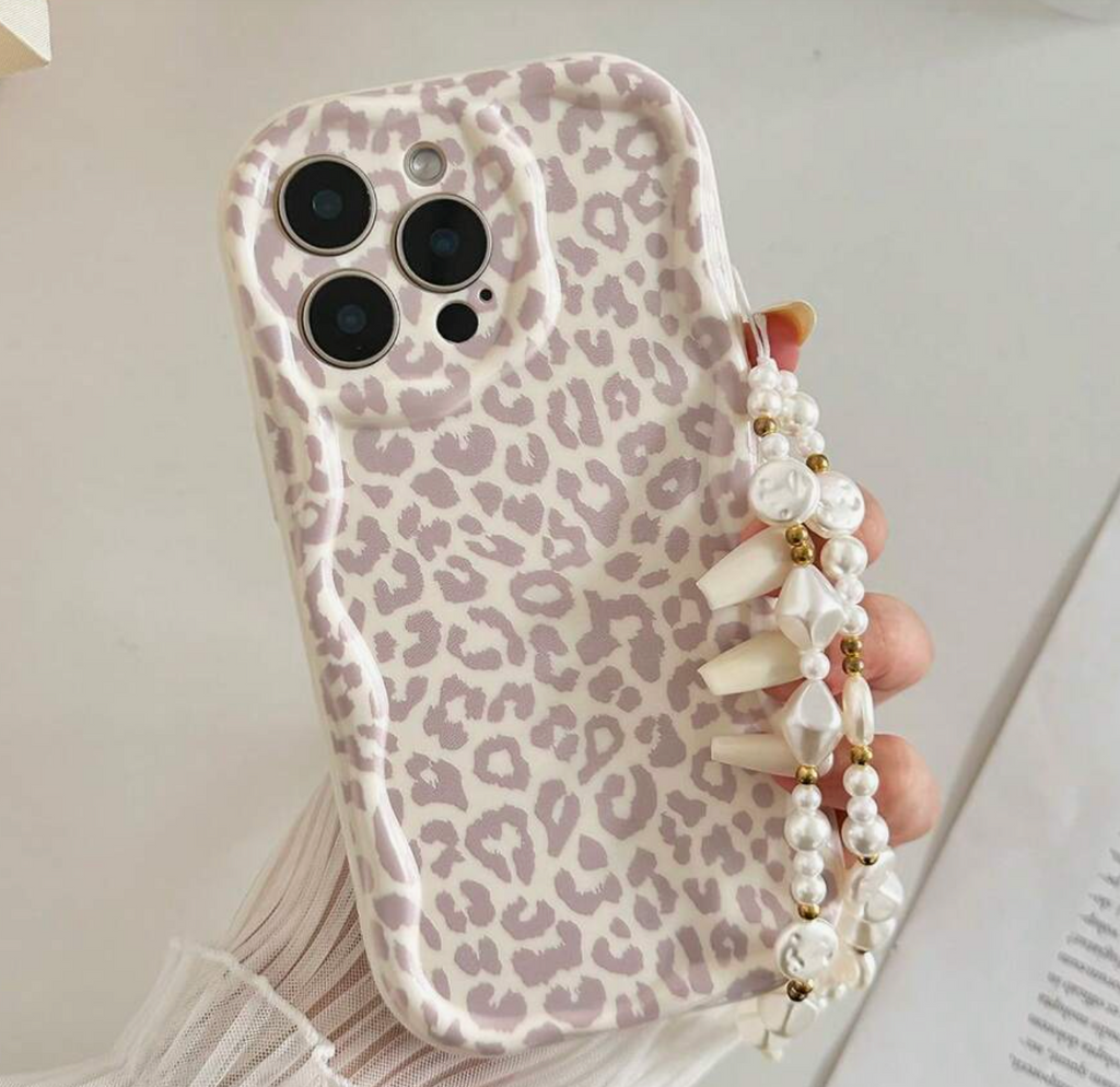 Phone case with leopard print design held by a hand with a pearl strap.