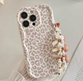 Phone case with leopard print design held by a hand with a pearl strap.