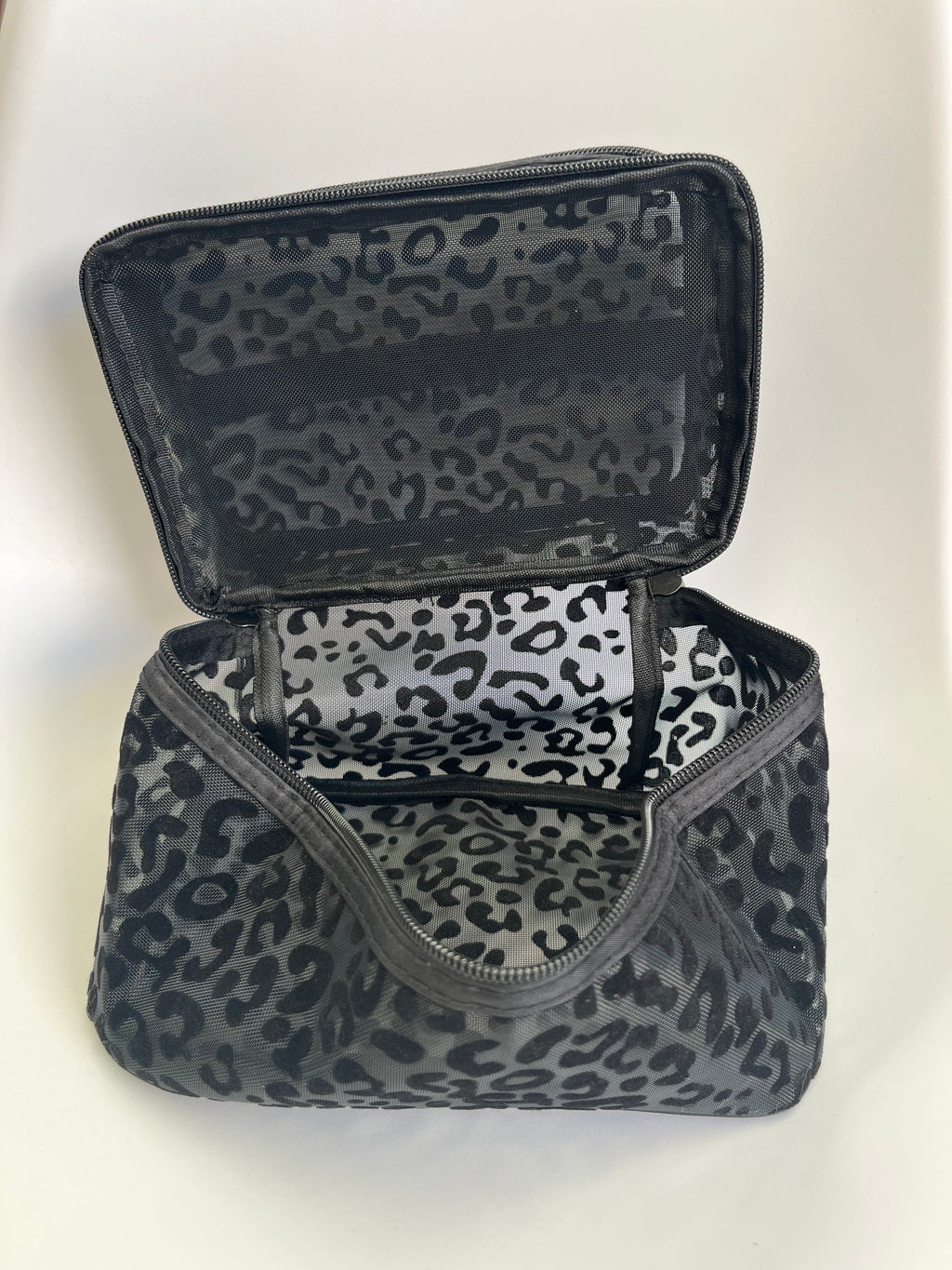 Black and white leopard print makeup bag on a white background