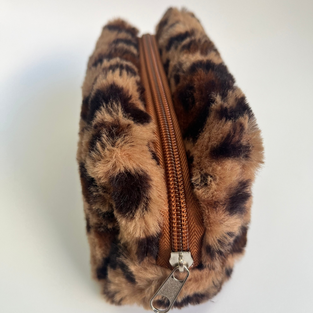 Leopard print pouch with a brown zipper on a white background