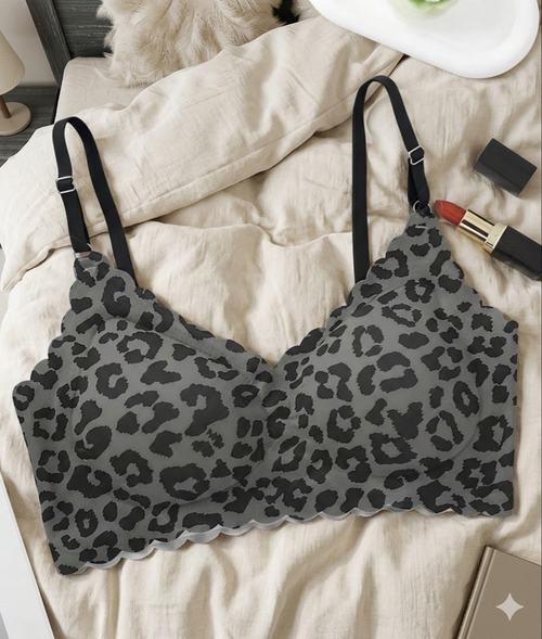 Leopard print bralette on a bed with makeup items.