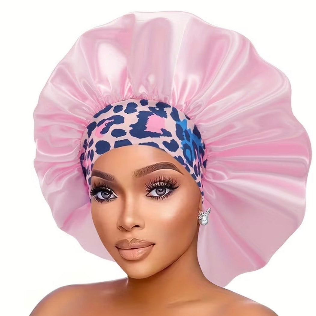 Woman wearing a pink satin bonnet with a leopard print band on a white background
