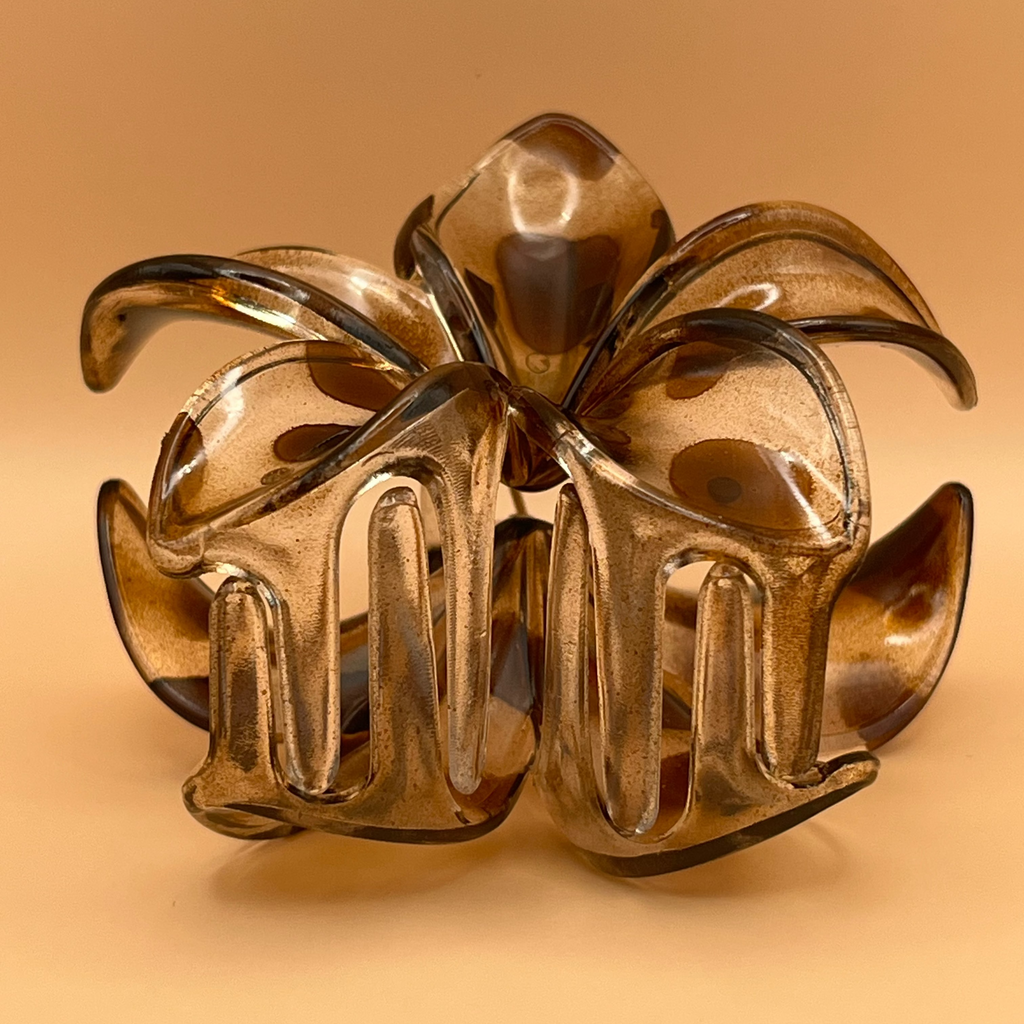Gold floral hair clip on a beige background