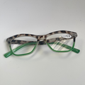 Eyeglasses with a leopard print frame and green arms on a white background