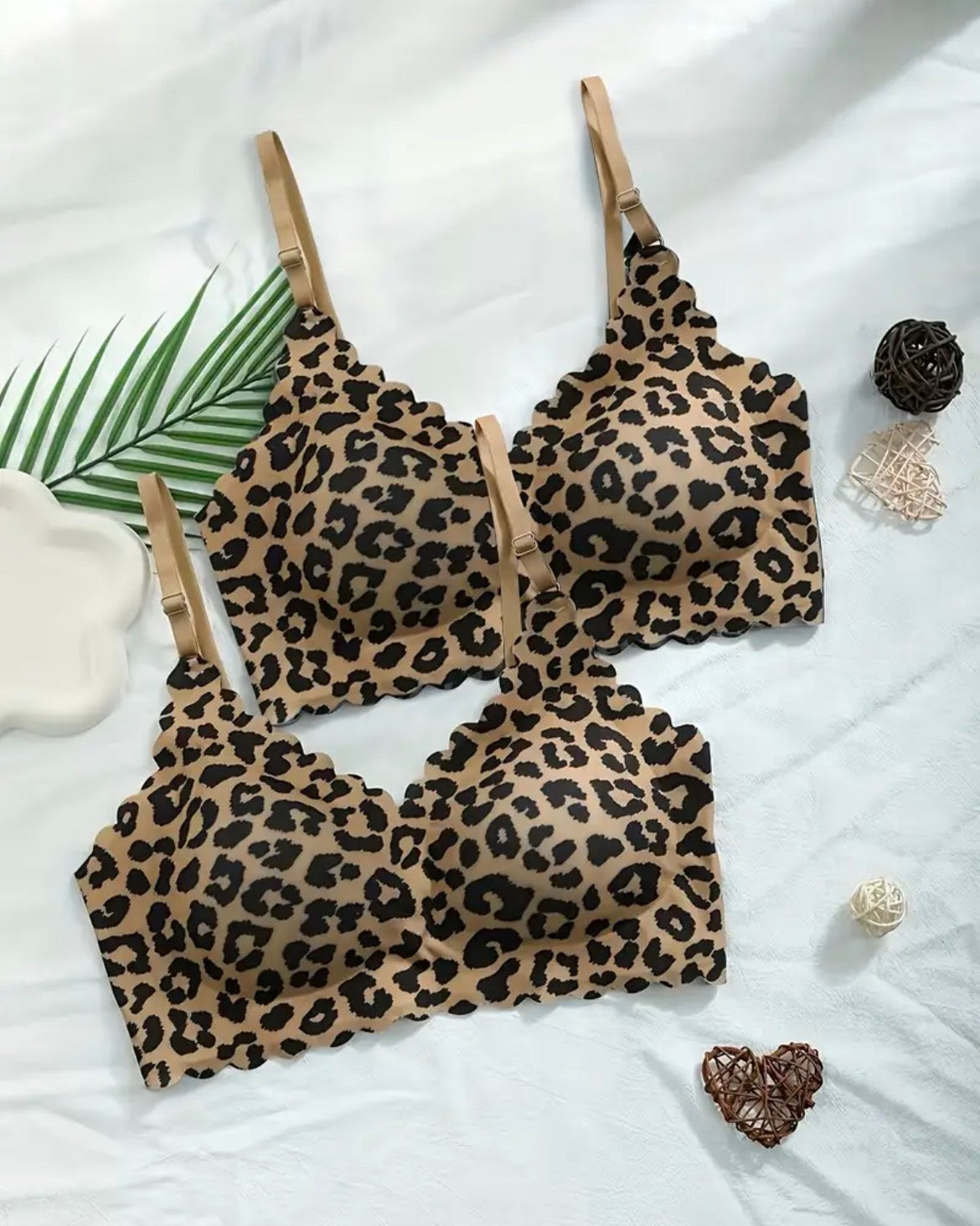 Leopard print lingerie set on a white surface with decorative elements.