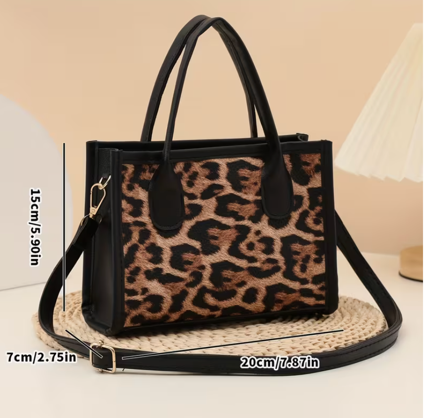 Leopard print handbag with black accents on a beige background