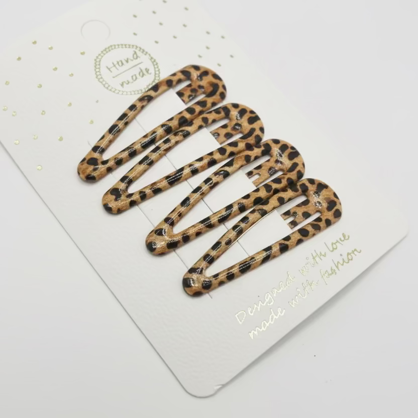 Set of leopard print hair clips on a white card with gold text.