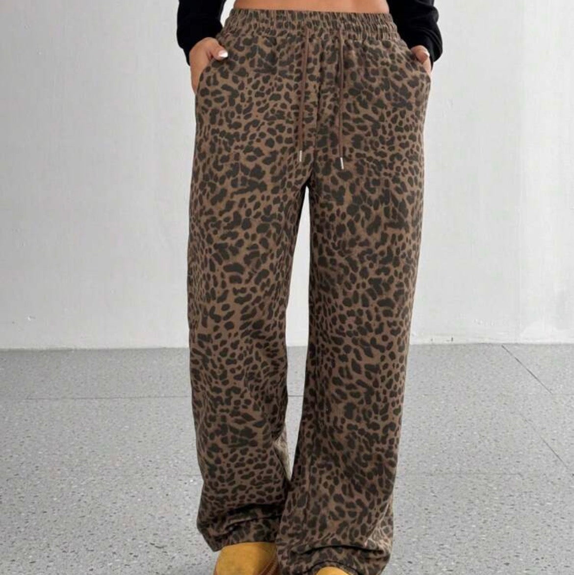 Leopard print pants worn by a person on a plain background