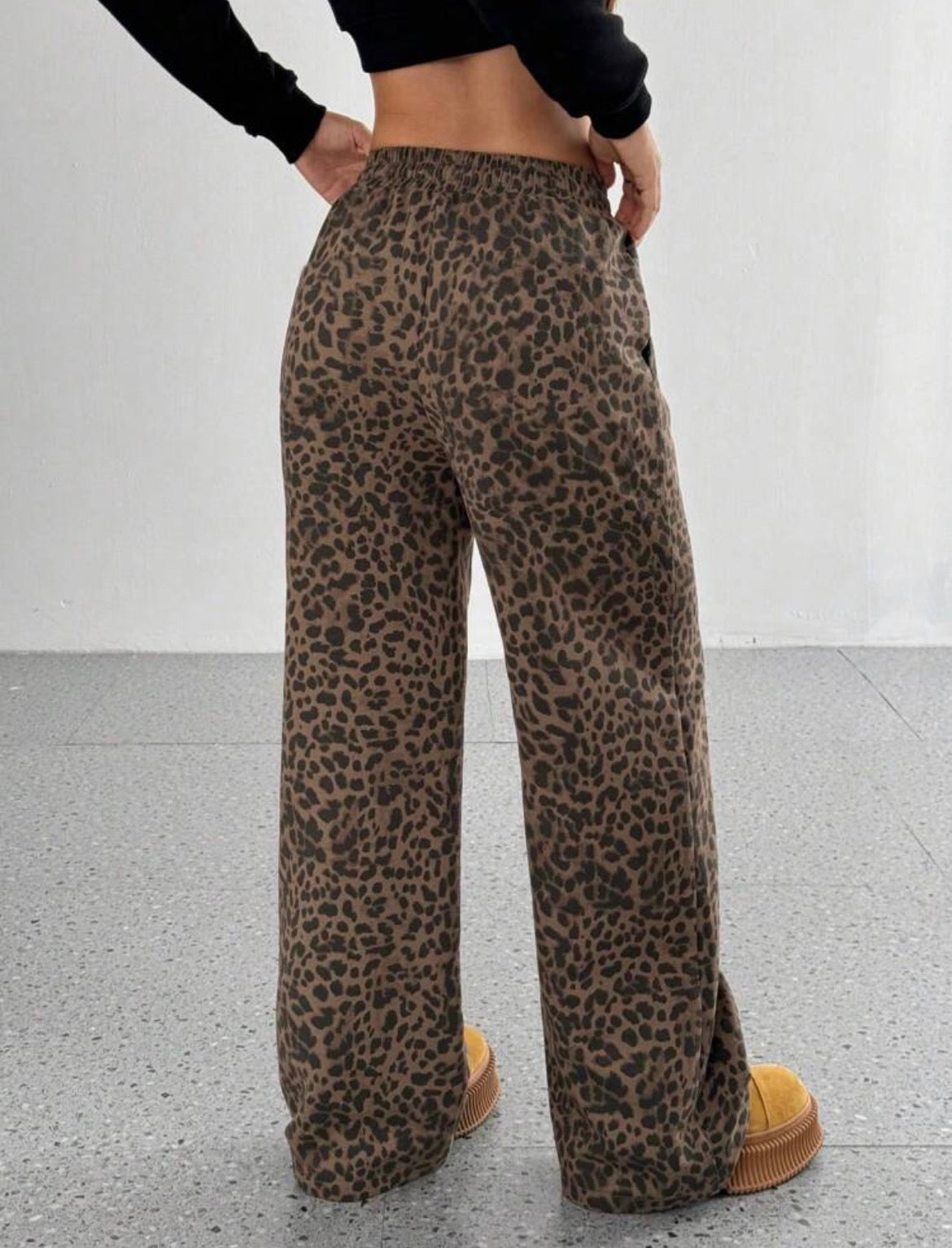 Leopard print pants worn by a person on a plain background