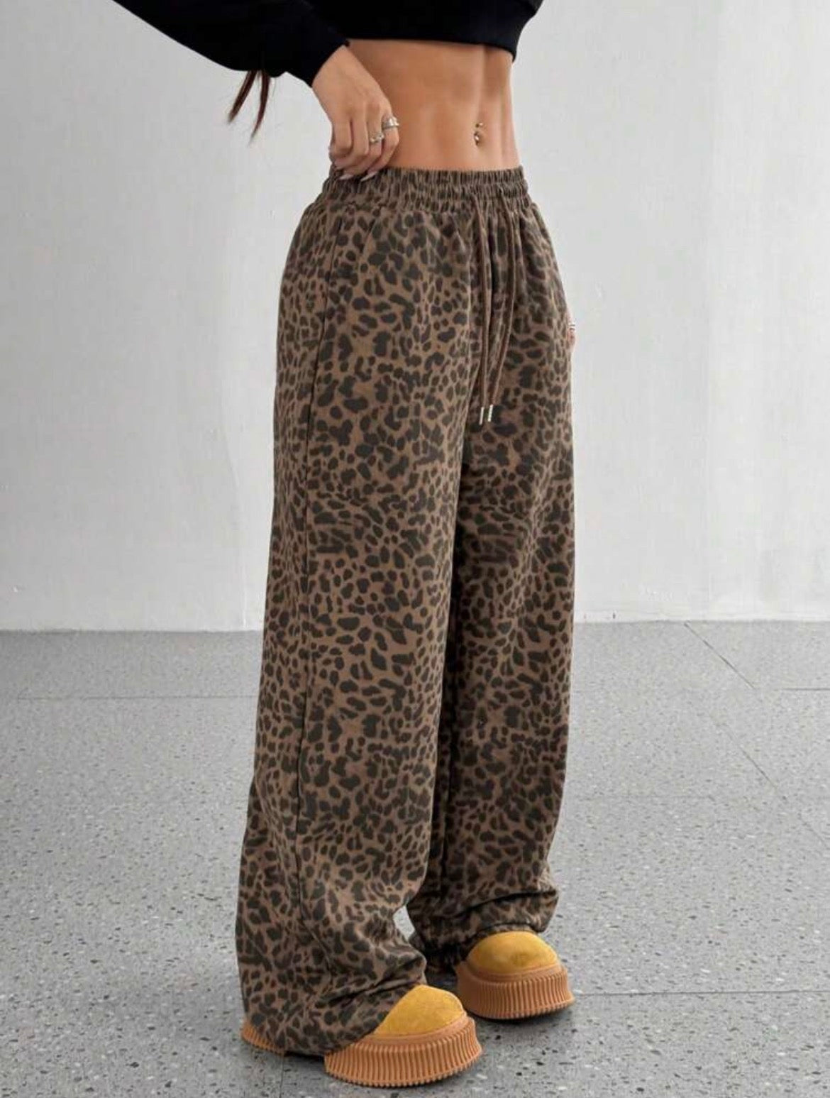 Leopard print pants worn by a person on a plain background