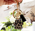 Keychain with leopard print paw charm held over a floral background