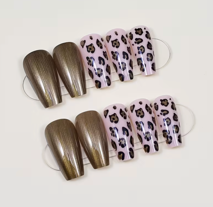 Set of false nails with metallic and leopard print designs on a white background