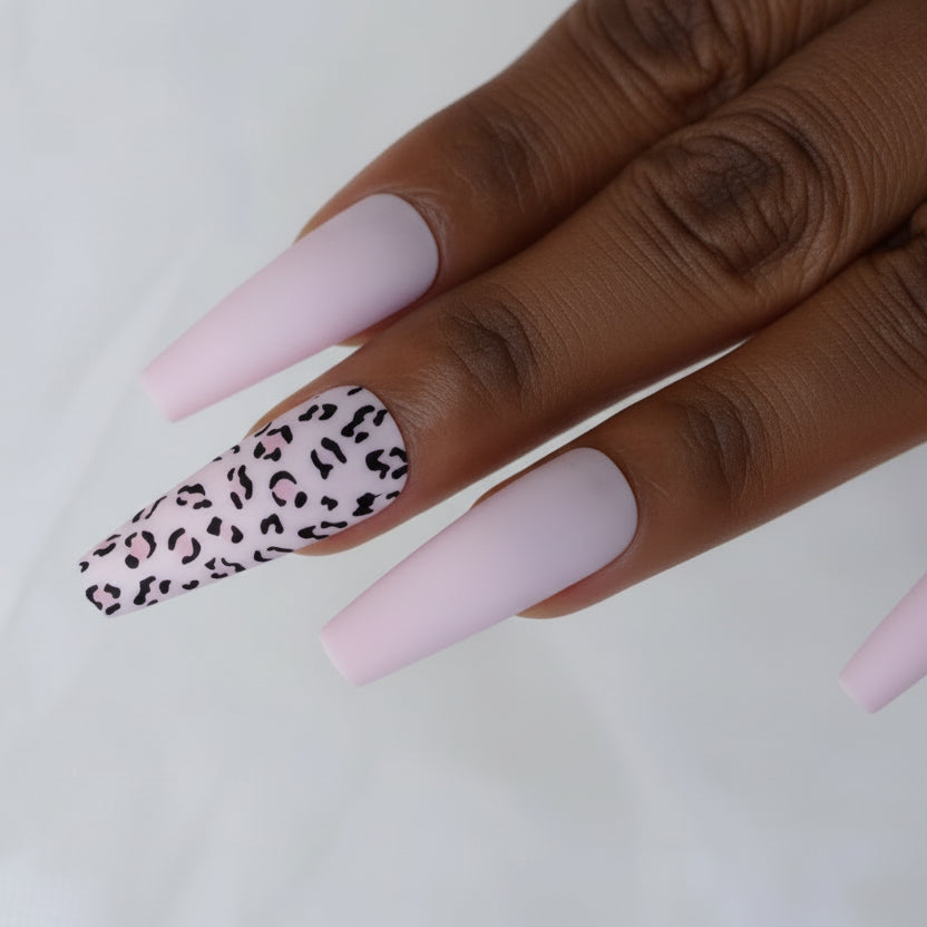 Hand with pink and leopard print nails on a white background