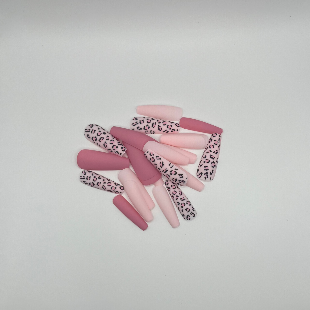 Set of pink and leopard print hair ties on a gray surface