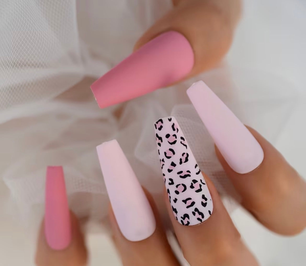Nail art with pink, light pink, and leopard print design on a neutral background