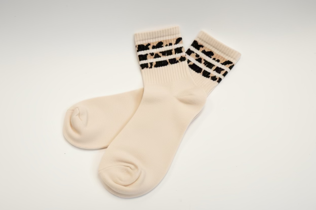 cream  socks with leopard print stripes on a light gray background