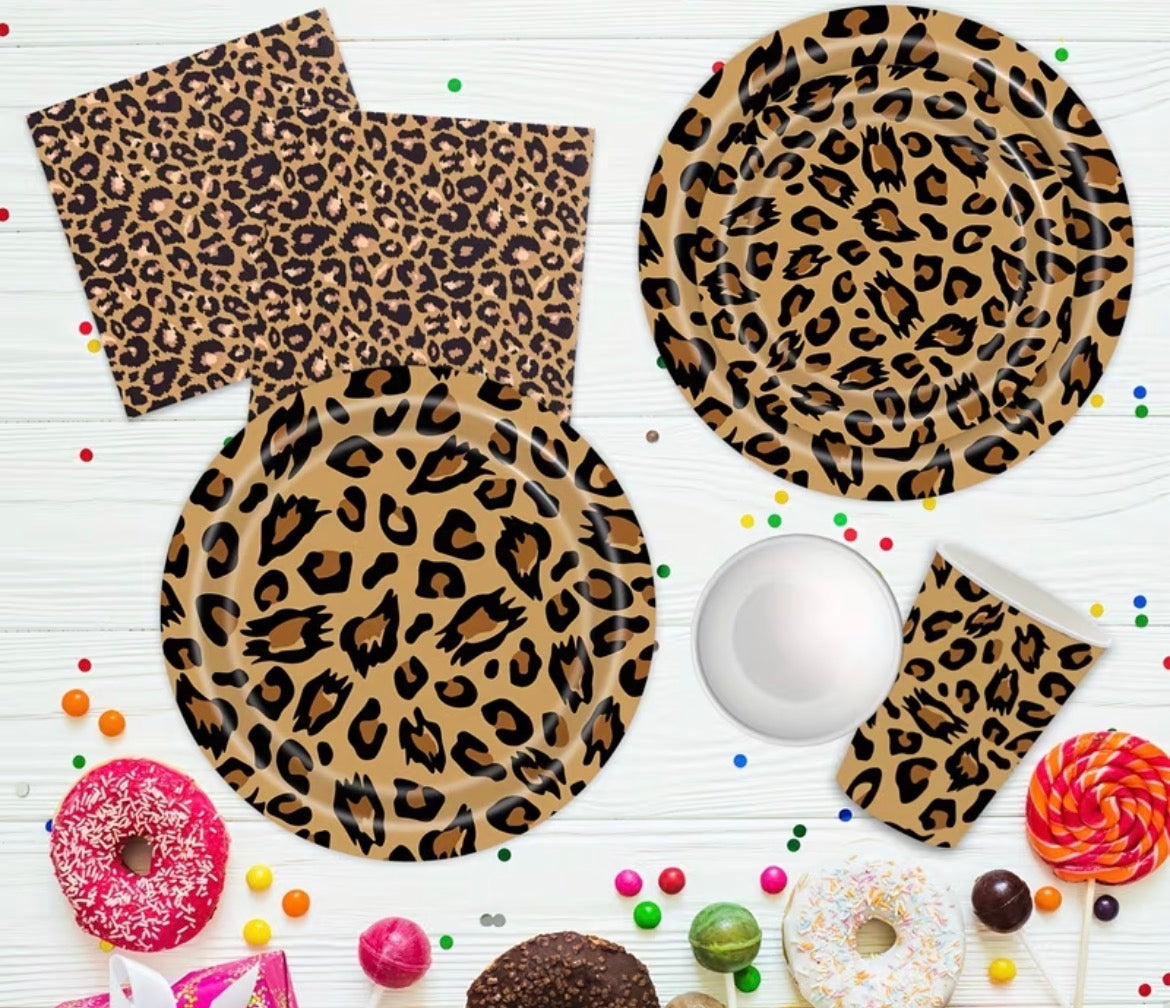 Leopard print tableware including plates and napkins on a white background with colorful candies.