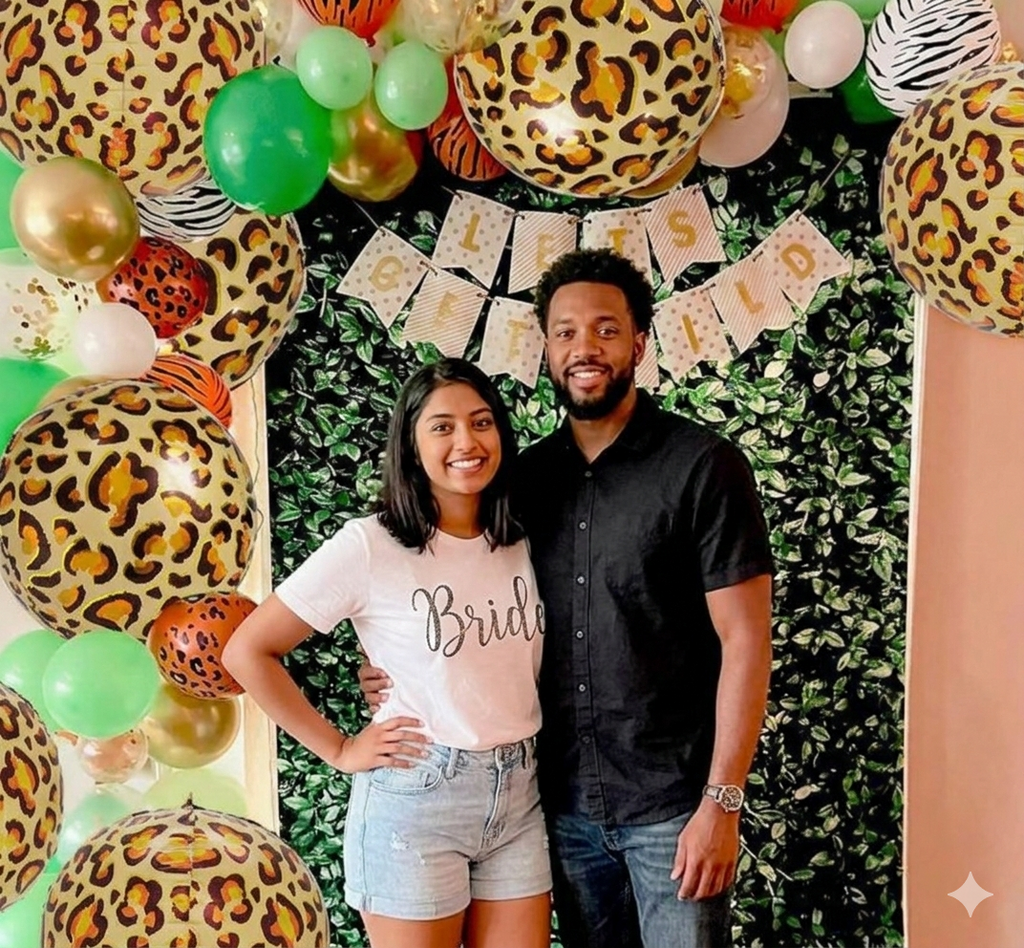 Two people posing in front of a decorated wall with balloons and a 'Brides' banner.