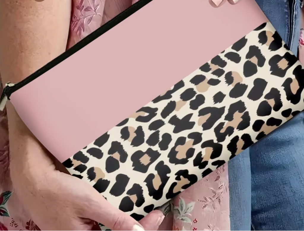 Person holding a pink make up bag with a leopard print 