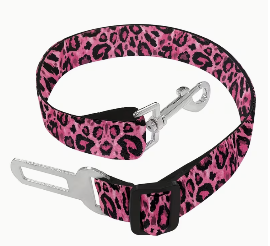 Pink leopard print dog seat belt with metal clip on a white background