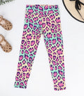 Colorful leopard print leggings on a white background with sandals and a hat.