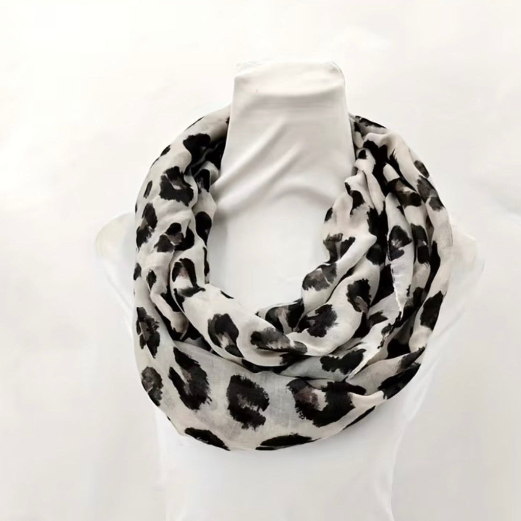 White scarf with black leopard print pattern on a white background