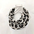 White scarf with black leopard print pattern on a white background