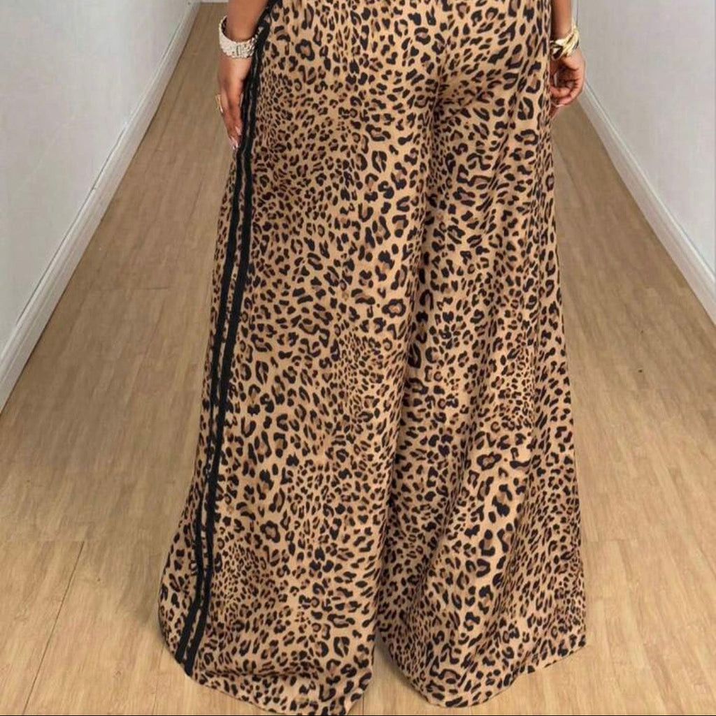 Person wearing leopard print pants with a plain background