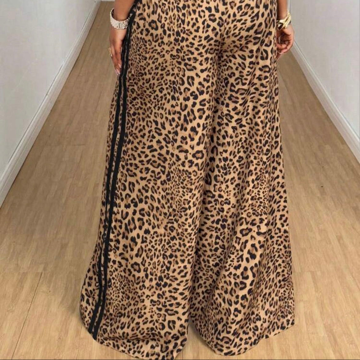 Person wearing leopard print pants with a plain background
