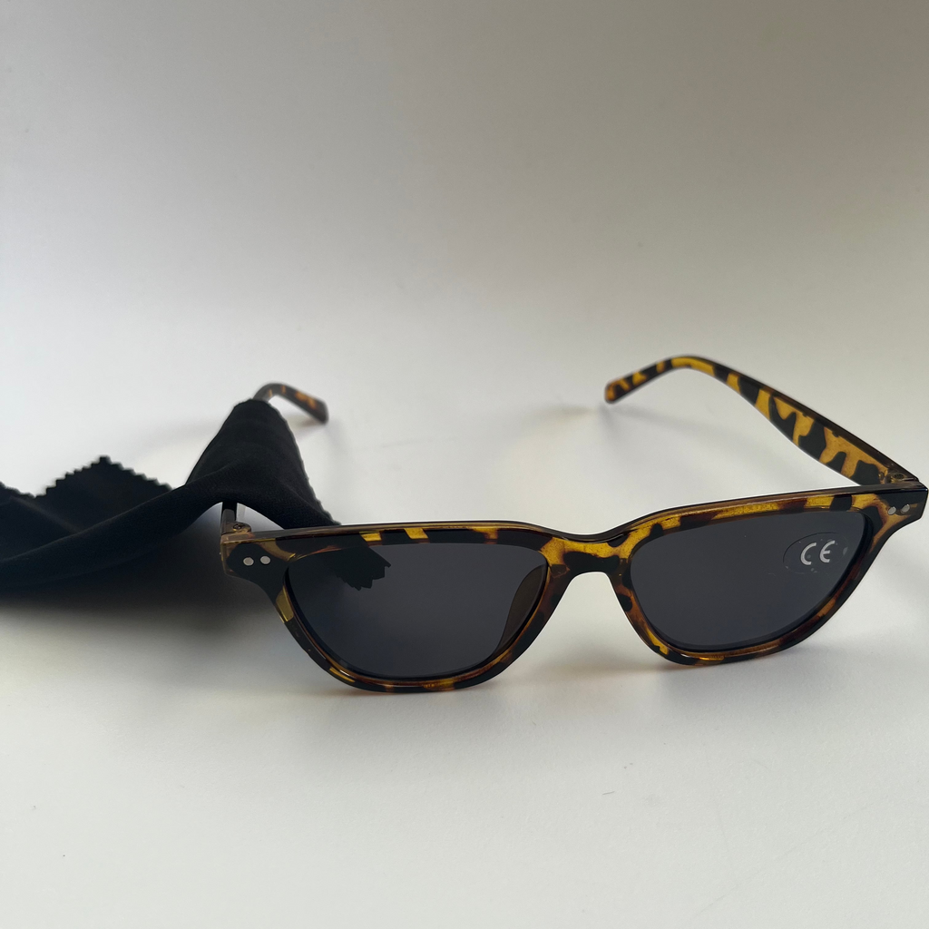 Sunglasses with tortoiseshell frame and dark lenses on a white background
