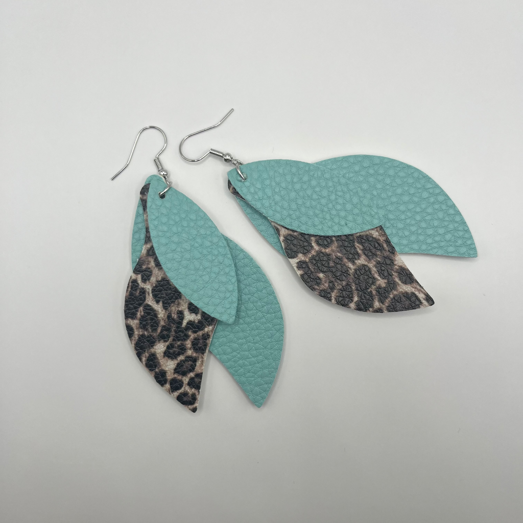 Pair of earrings with turquoise leaves and leopard print accents on a white background